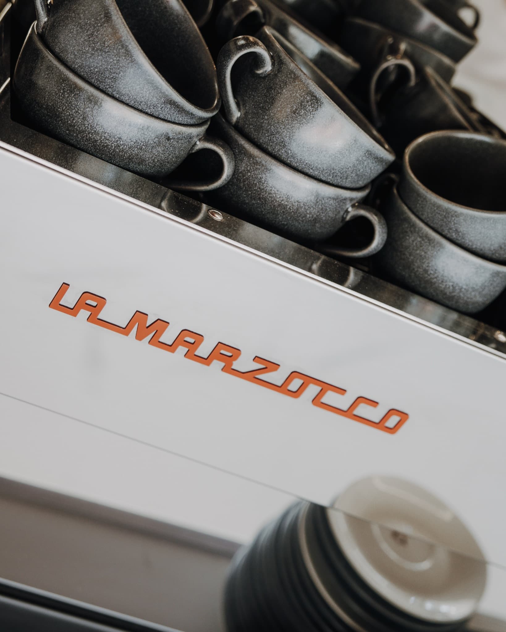 Nuestra máquina La Marzocco con las tazas de gres apiladas encima